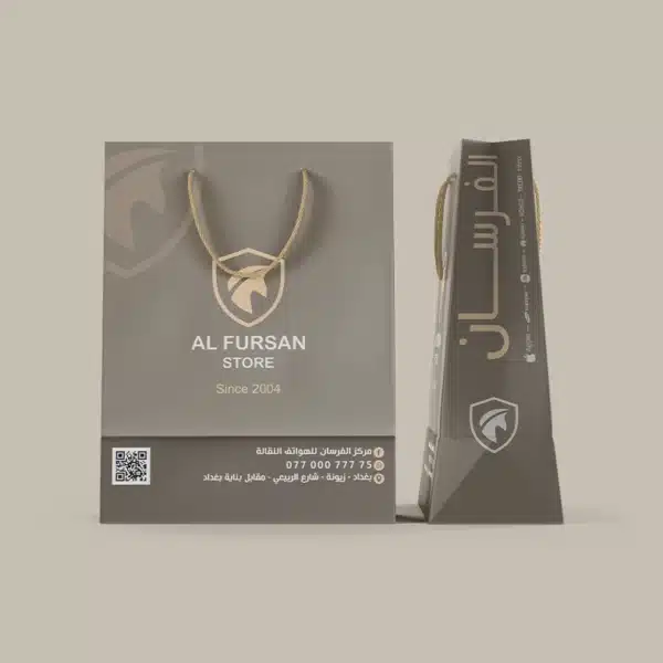 أكياس كرتونية بتصميم فاخر لشركة الفرسان للموبايلات في بغداد، تظهر الواجهة بشعار AL FURSAN STORE ومعلومات التواصل وQR مع عرض جانبي للكيس 